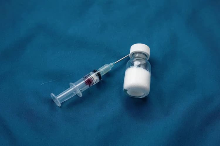 Kit de tratamento médico com seringa, agulha e frasco de espuma esclerosante.