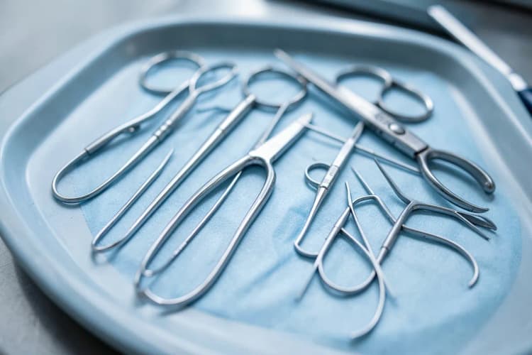 Conjunto de instrumentos médicos cirúrgicos organizados em uma bandeja.