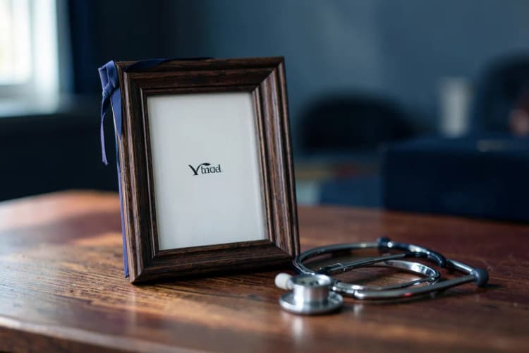 Um diploma de medicina em um porta-retrato sobre uma mesa com um estetoscópio ao lado