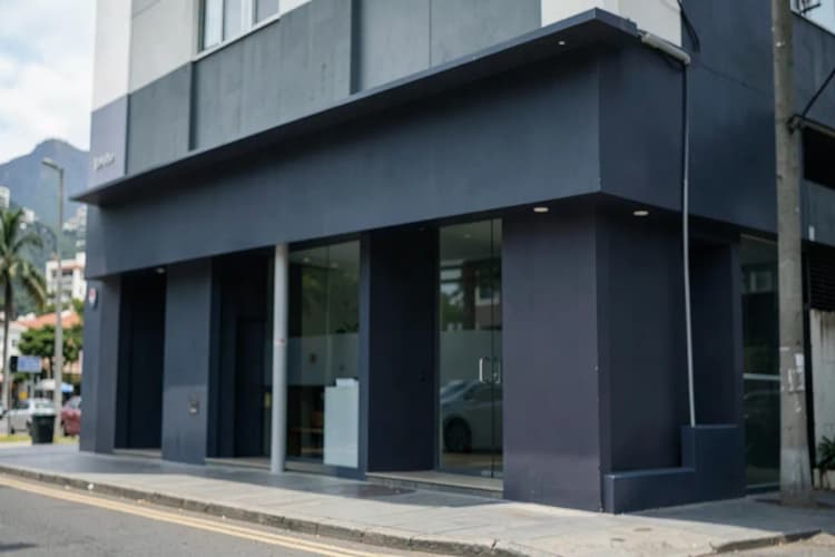 Fachada moderna de uma clínica médica com sinalização discreta na Barra da Tijuca, Rio de Janeiro.